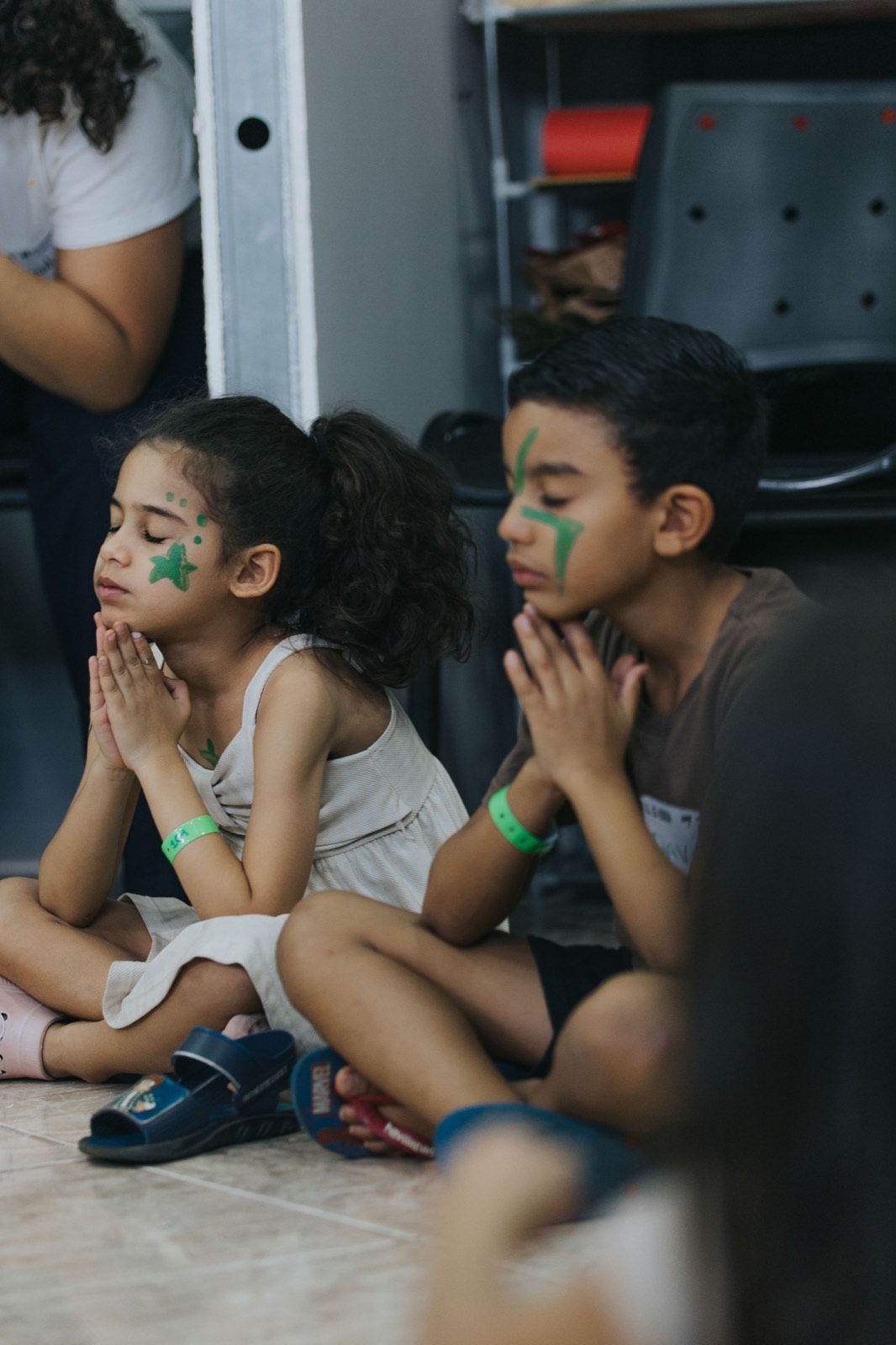 Duas crianças de olhos fechados em oração