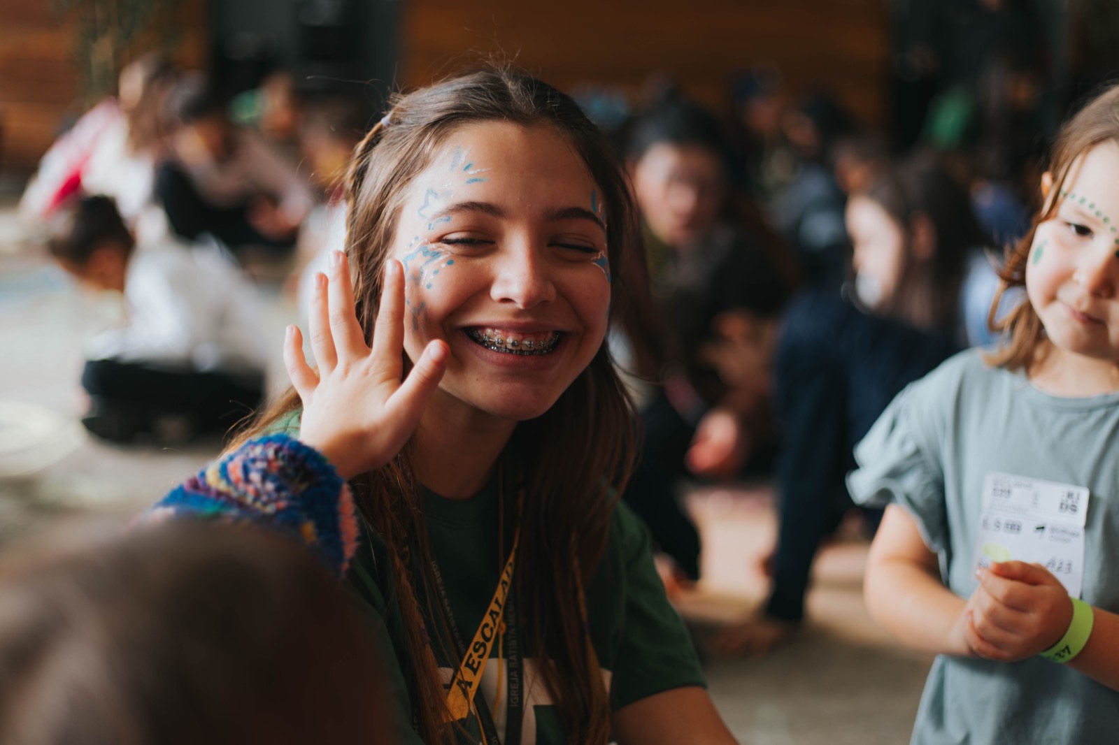 Menina sorrindo com pintura no rosto durante uma brincadeira